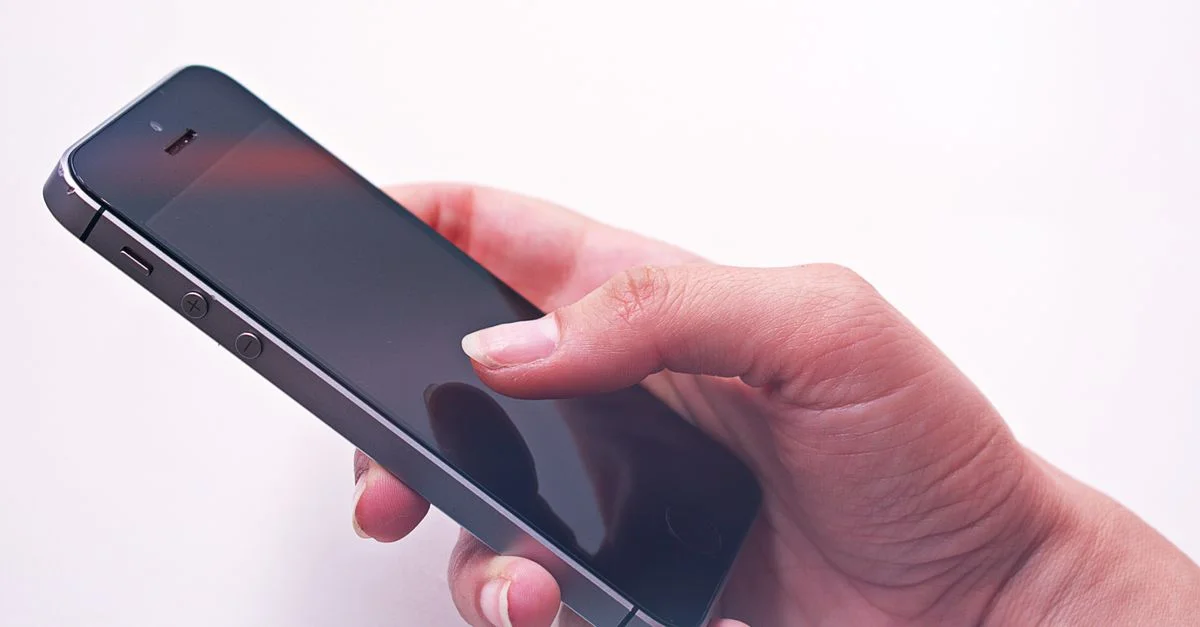 La main d'une personne tenant un smartphone, mettant en avant la technologie moderne et la connectivité.