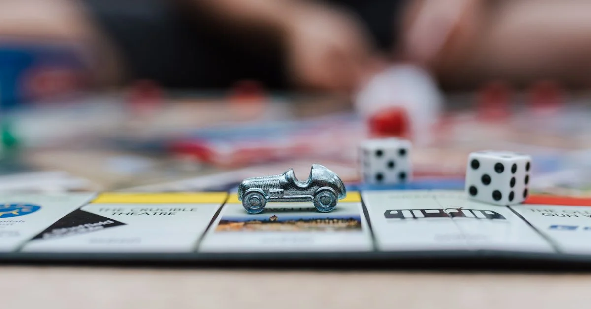 Plan détaillé d'un plateau de jeu Monopoly avec une voiture jouet et des dés, parfait pour des thèmes de divertissement familial.